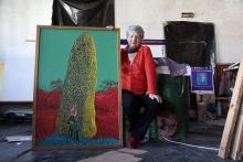 Marie-Josée à côté de son tableau au menhir, une oeuvre collective avec Odile Le Bras.
